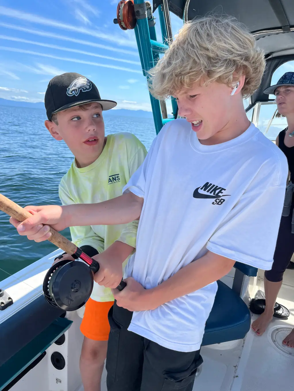 two boys wrestling with a salmon on the line near Comox