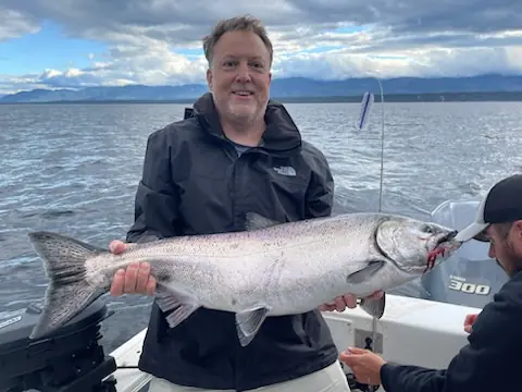 man showing the salmon he just caught near Comox