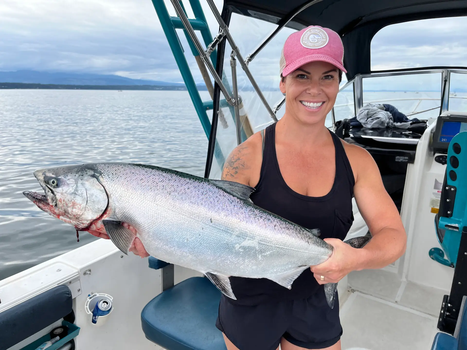 woman showing off salmon caught near Comox