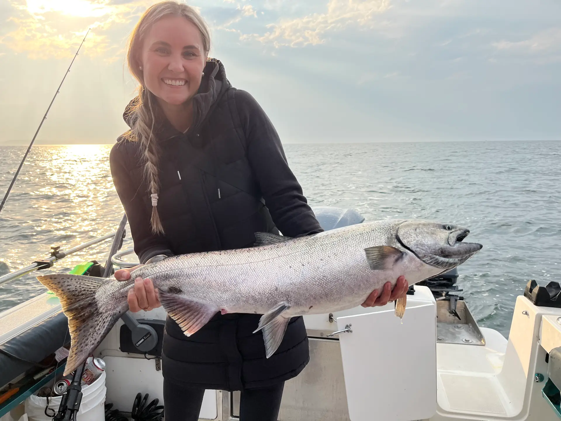 woman proudly showing off a large salmon caught off Campbell River