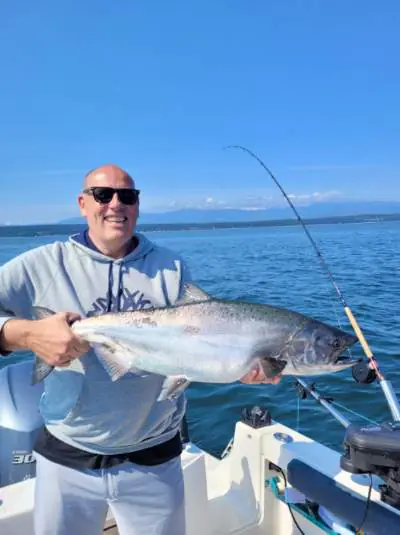 man showing off a large salmon