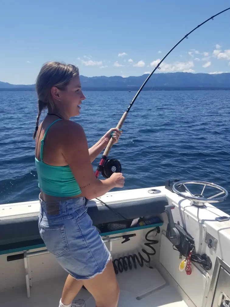 woman reeling in a large fish off Campbell River