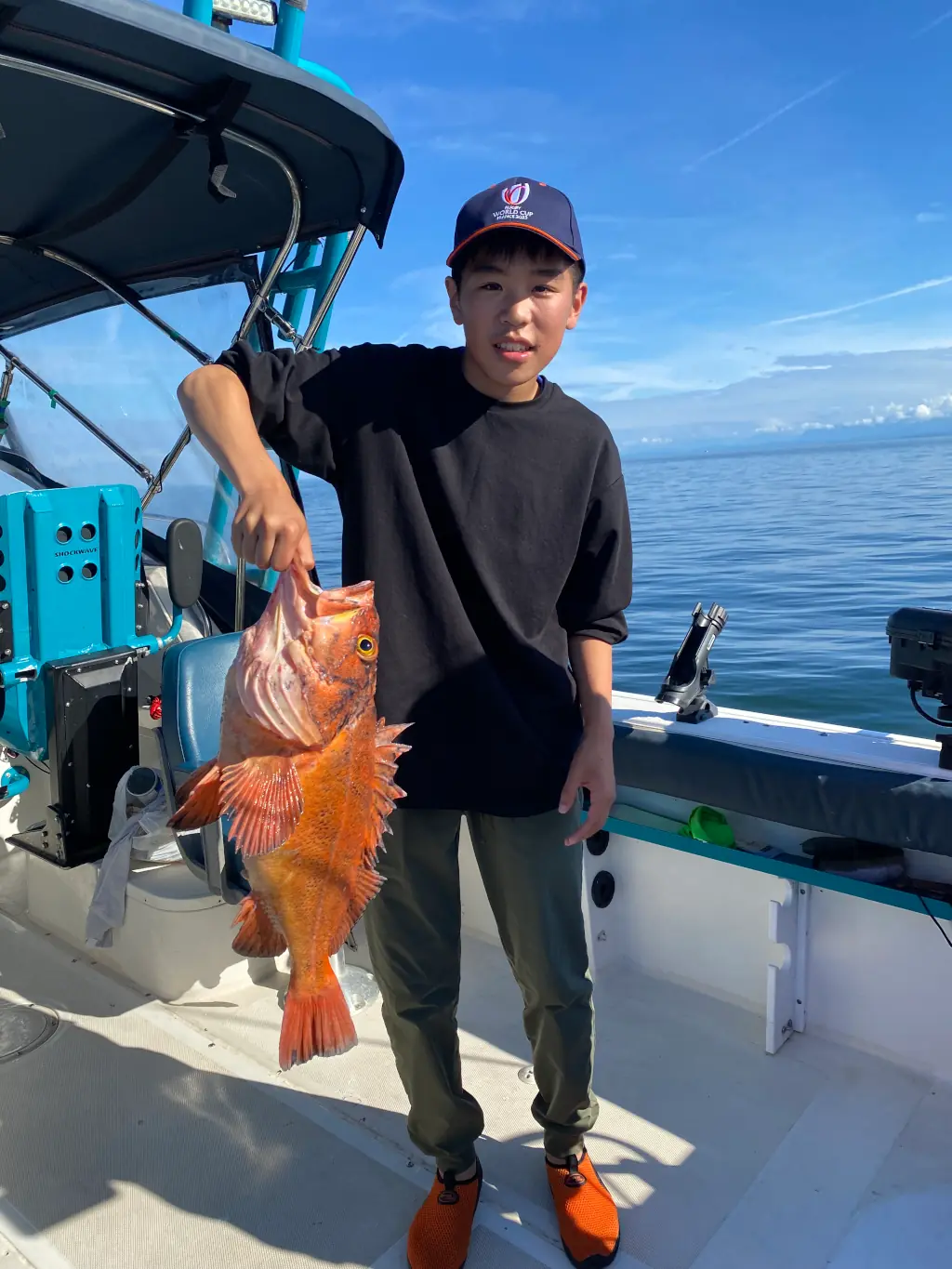 boy holding up a cod caught off Comox
