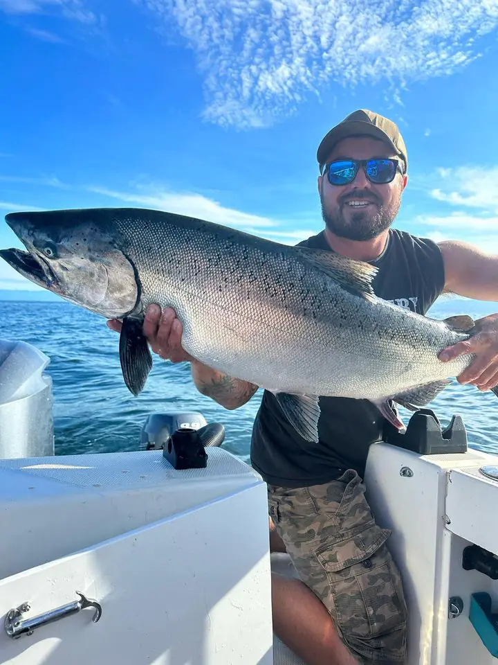 man holding up a salmon caught on a charter