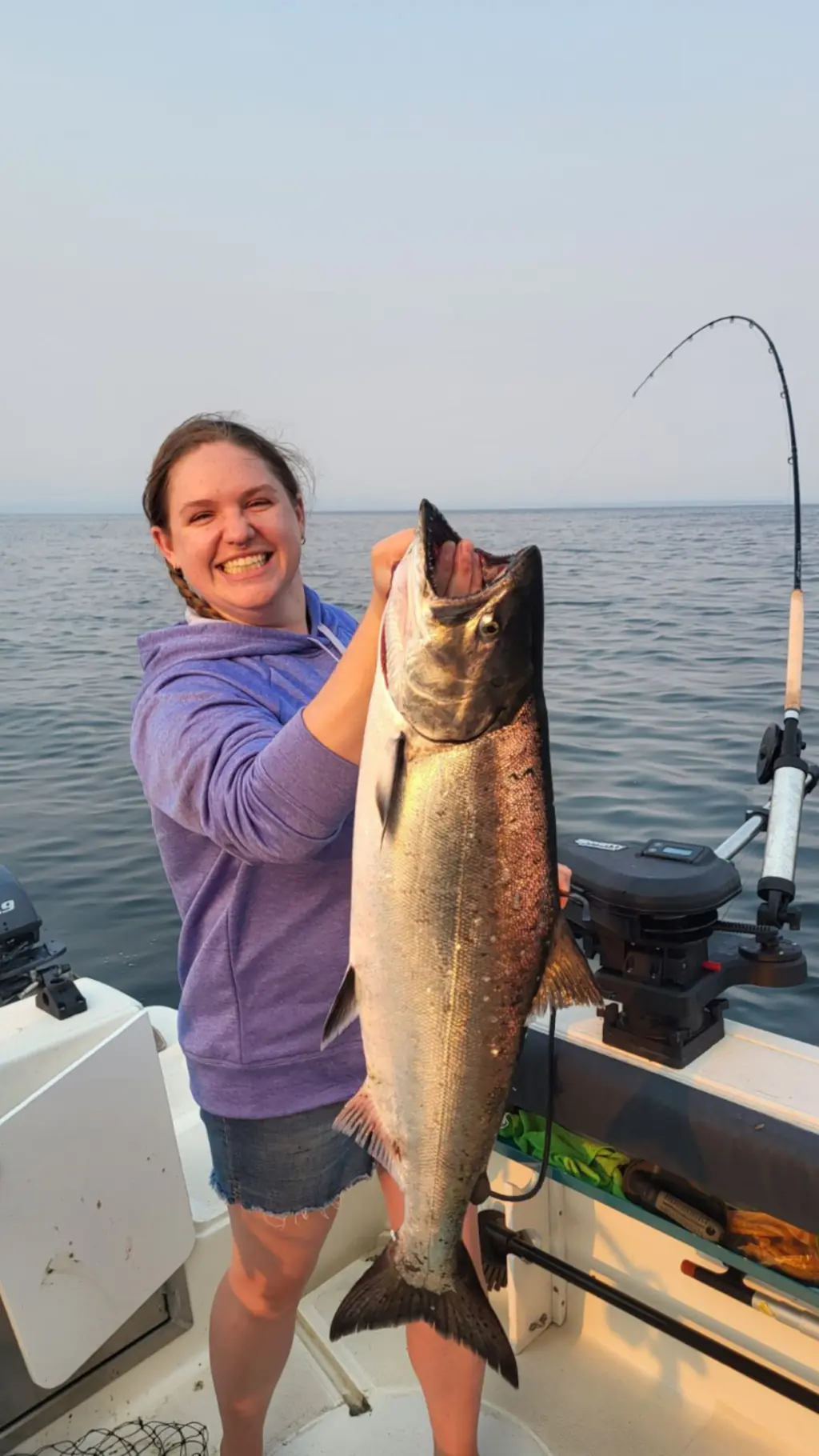 smiling woman displaying a large salmon caught near Campbell River