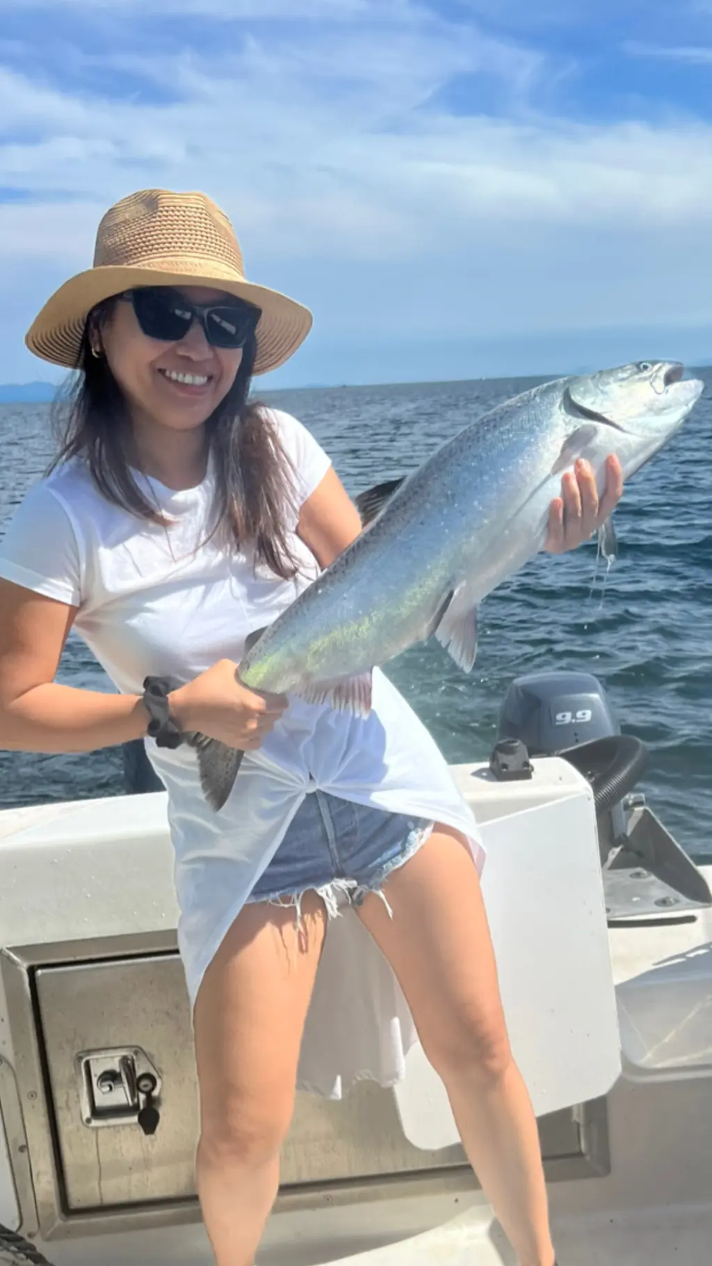 woman holding up a large salmon just caught
