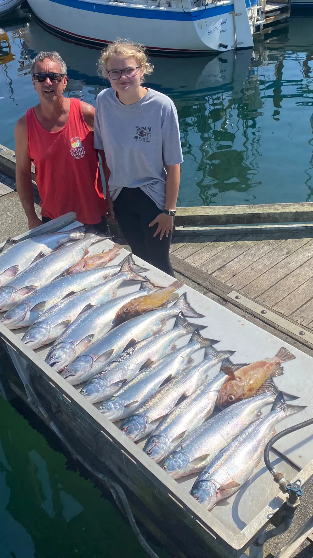 dad and daughter showing off a massive haul of salmon caught off Comox