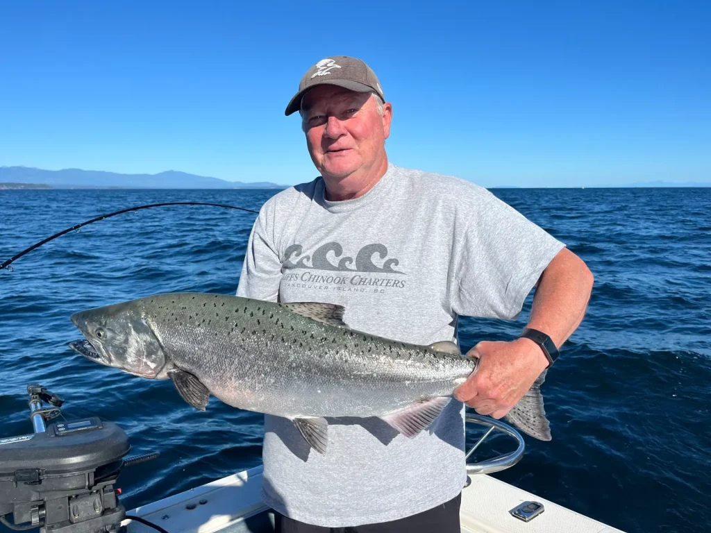 man displaying a large salmon he just caught