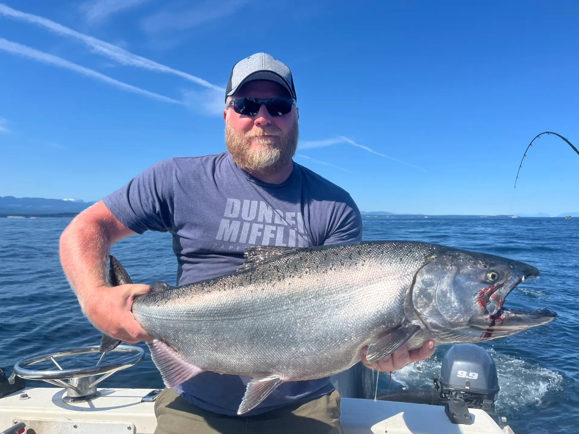 man displaying a large salmon caught near Comox