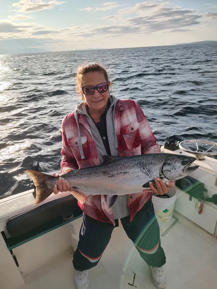 woman holding large salmon in the waters of Comox