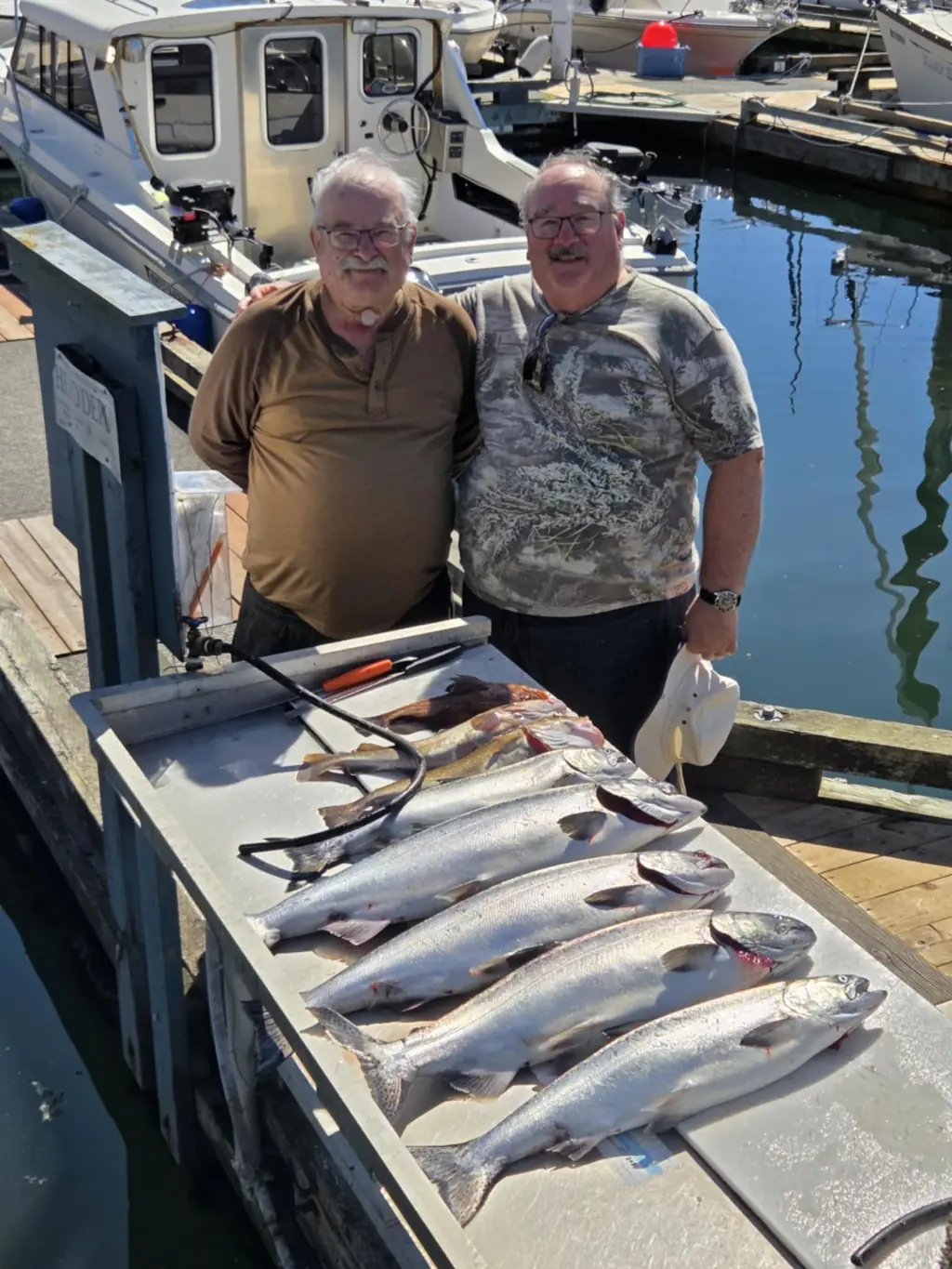 two men showing the fish they caught near Comox