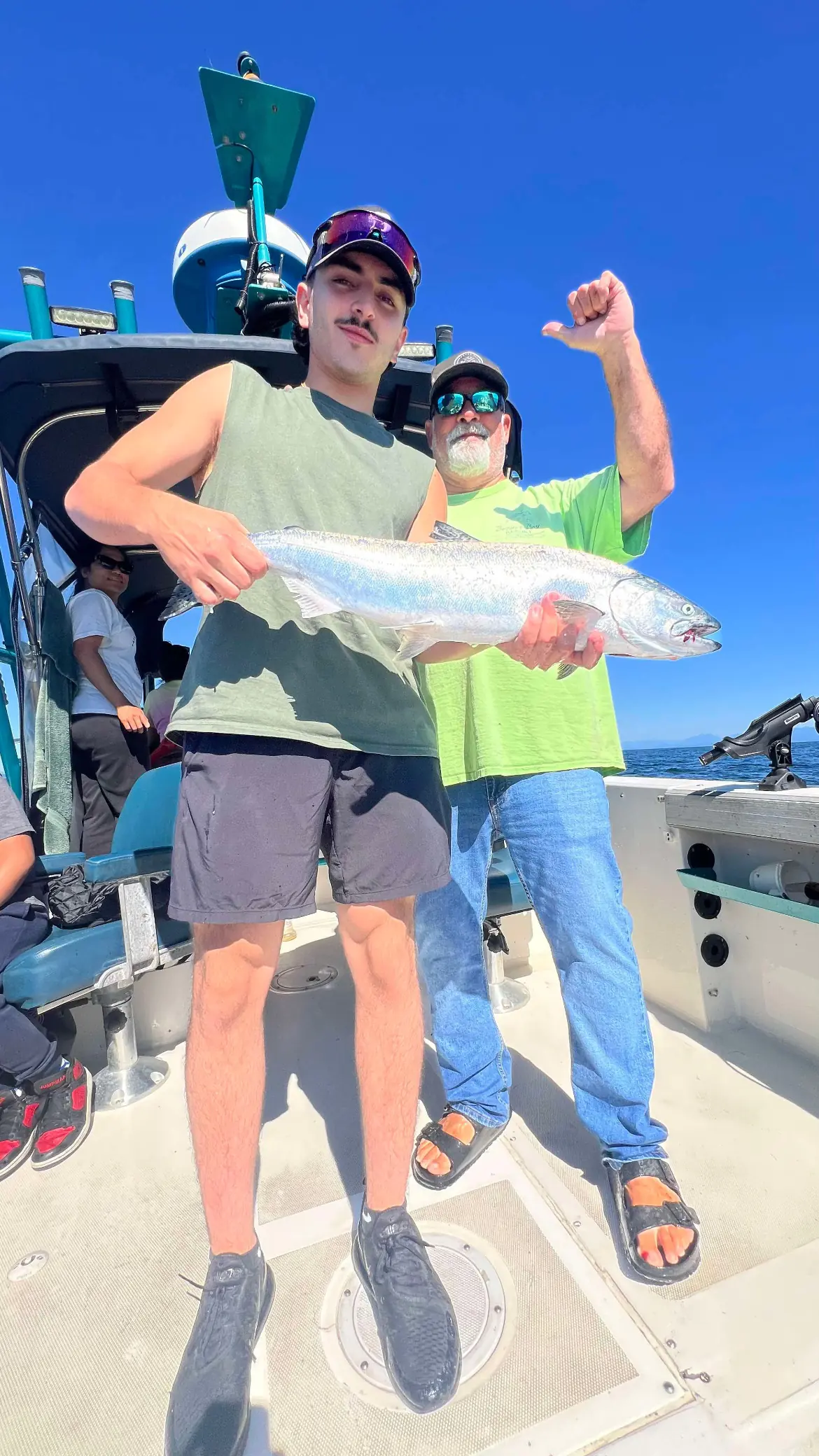 two men showing off a large salmon caught near Comox